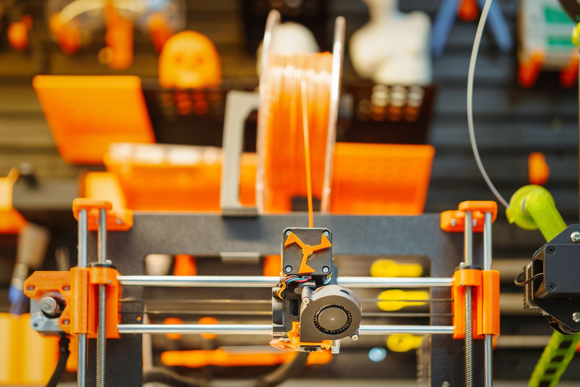 Close-up of an advanced 3D printer extruding filament in a workshop setting