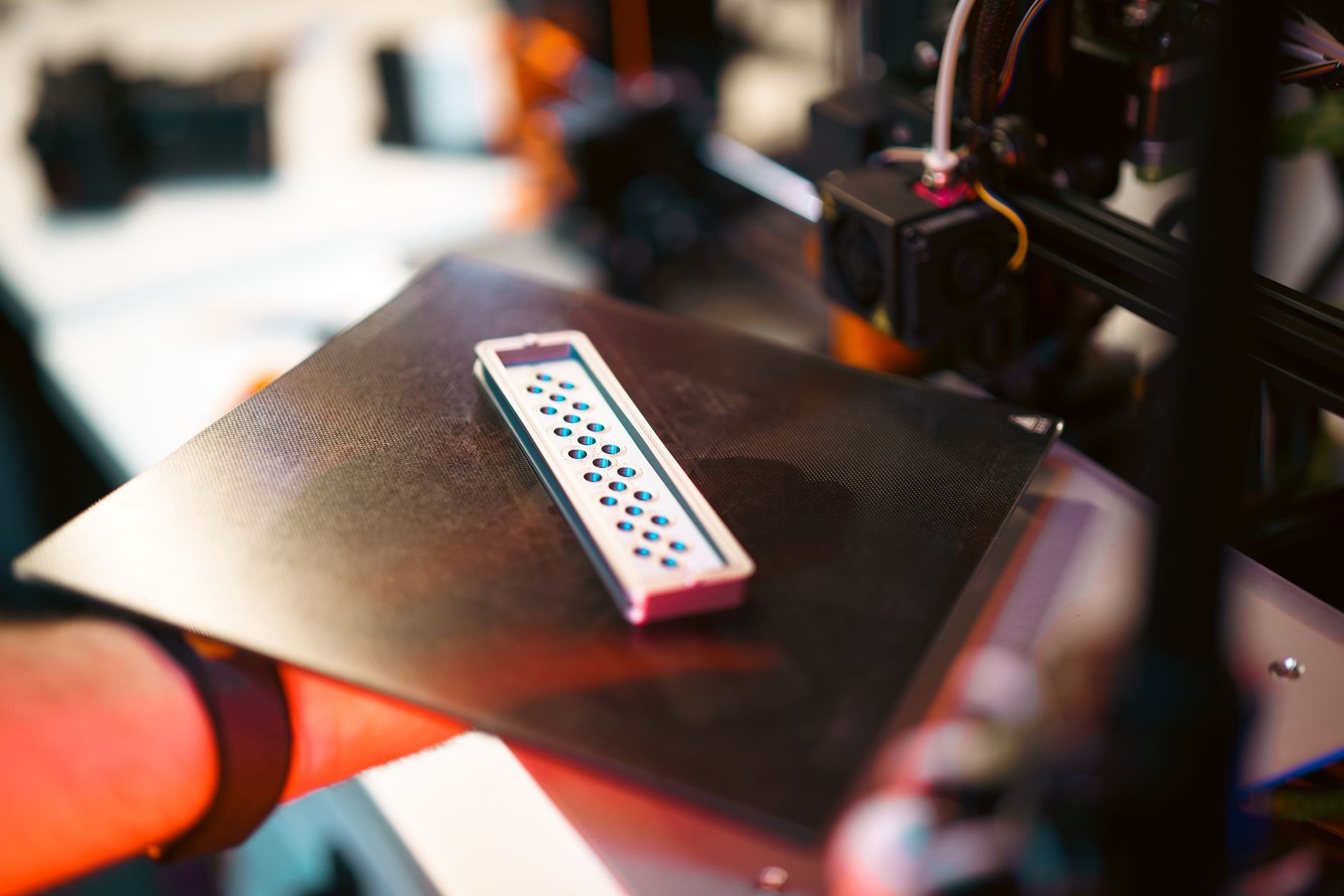 Close-up of a 3D printed part on an industrial printer in a workshop setting
